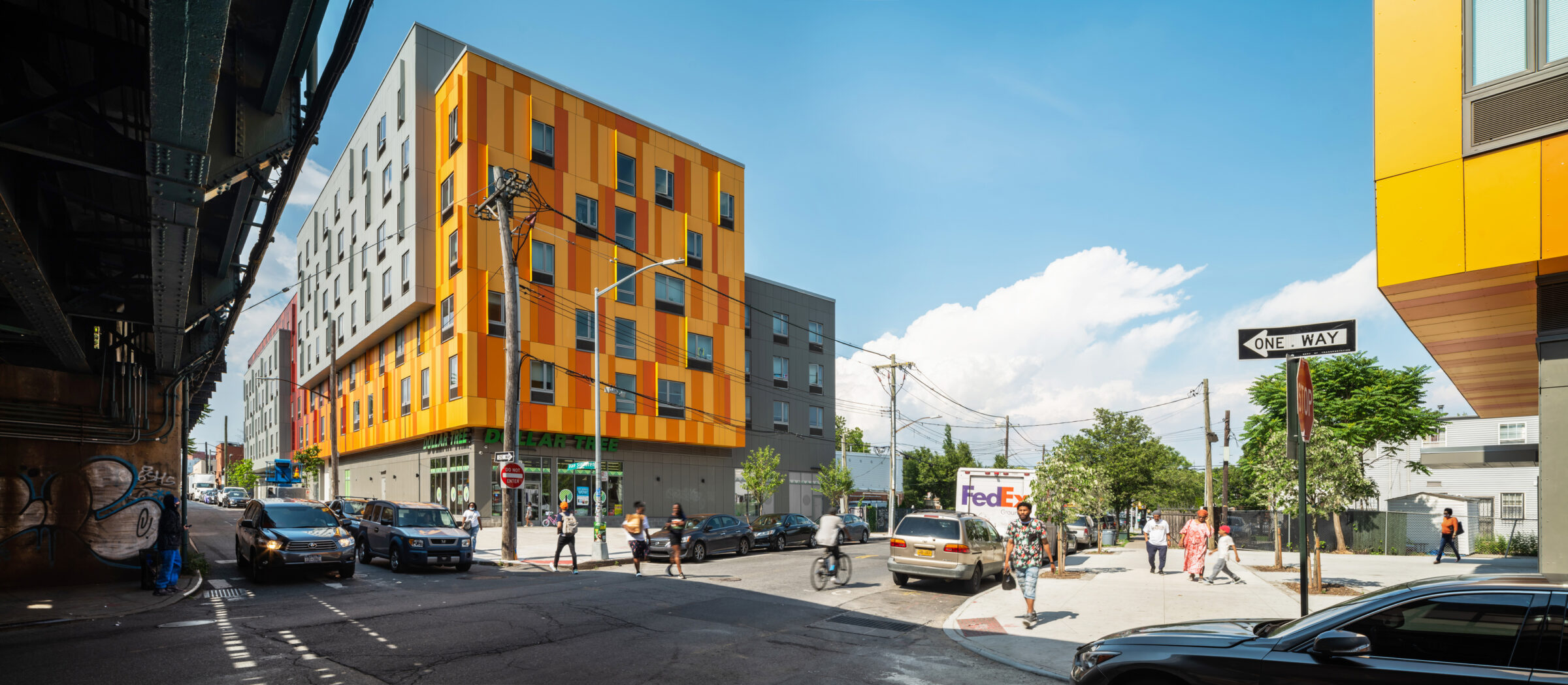 Van Sinderen Plaza — gateway plaza at street level with the orange-paneled facade and elevated subway